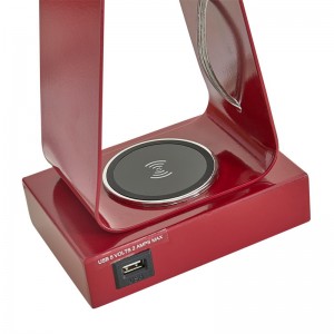 Kleine desklamp met rode afwerking, een USB -oplaadpoort, een draadloos oplaadstation en een op/off rocker -schakelaar in de kamer