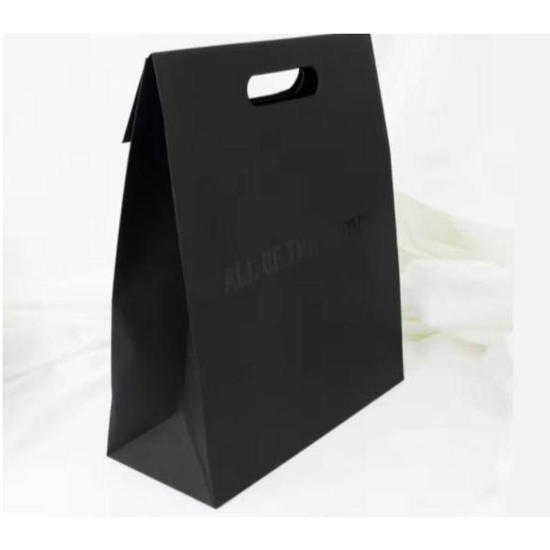 Luxe Die gesneden handvat Zwarte Kleding Kleding PAKKOPPACTAGE Papiertas Cosmetische Custom Logo Wikkelontwerp Papiercadeauzakken